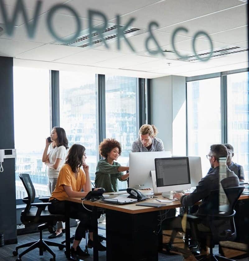 Equipo de trabajo colaborando en oficina de agencia digital